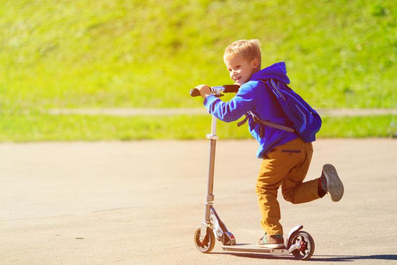 快乐的小男孩骑滑板车