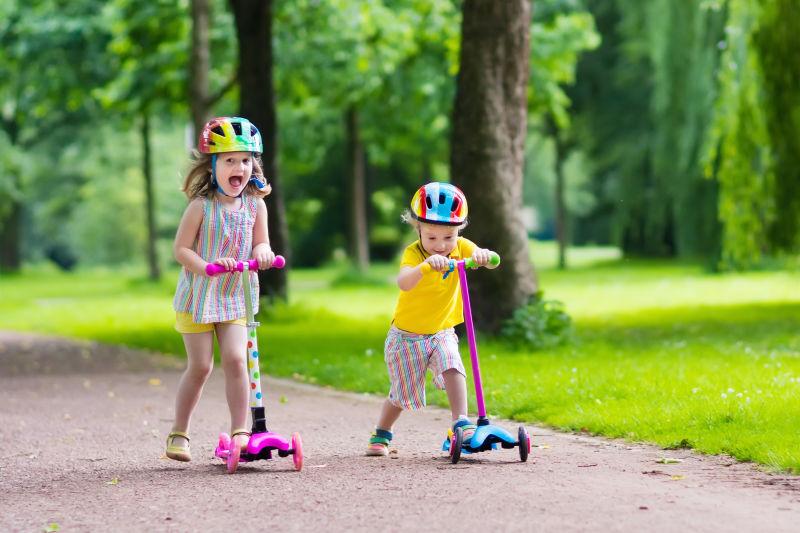 夏日孩子们在公园里学骑滑板车