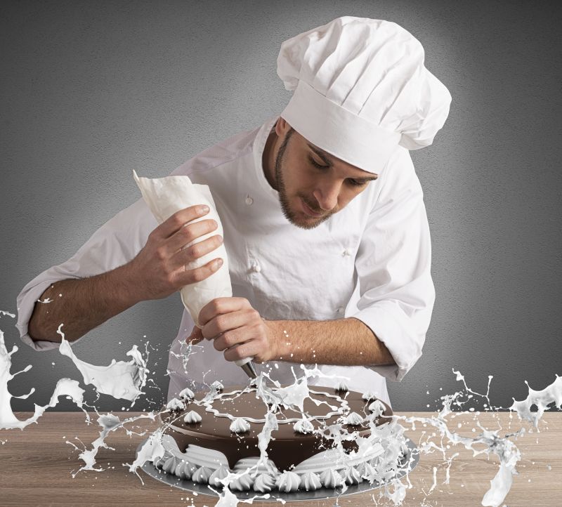 糕点厨师用奶油装饰蛋糕