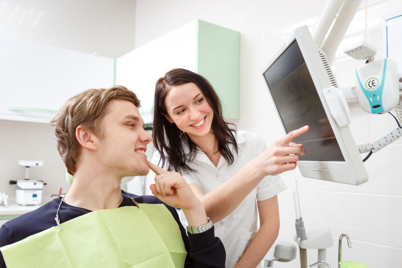 牙科医生在牙科诊所为病人讲解X光片