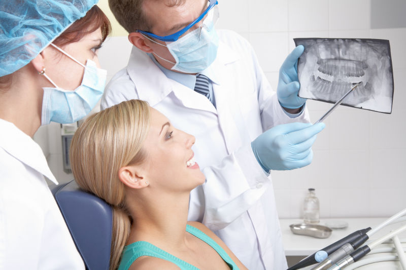 牙科医生给病人看她的牙齿X光片