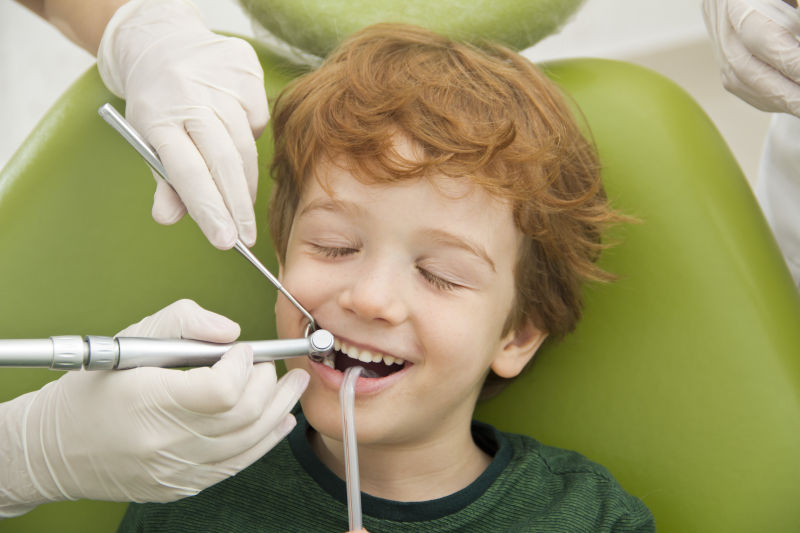 牙医为小男孩检查牙齿问题