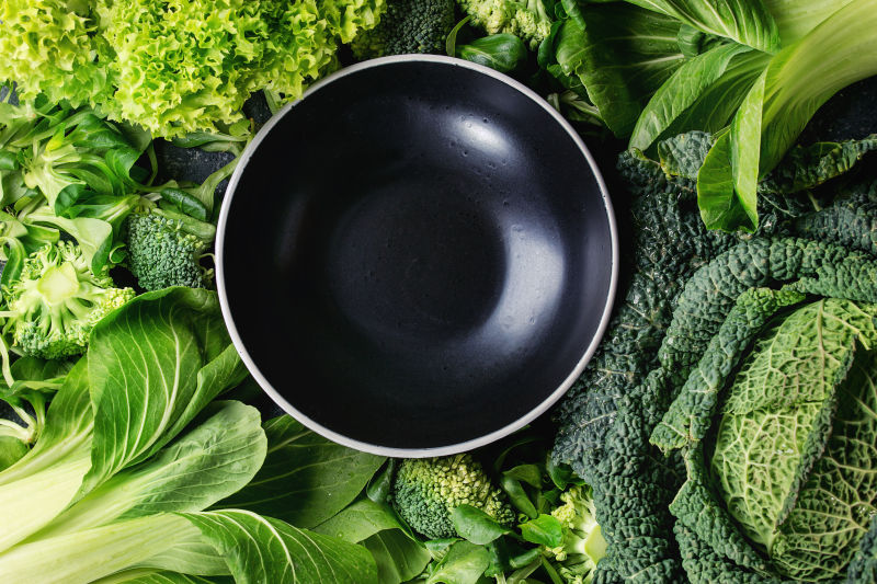 各种绿色蔬菜和中间的黑色碗