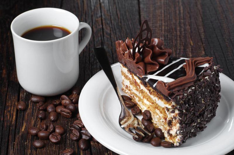 黑木桌上的巧克力蛋糕和咖啡杯