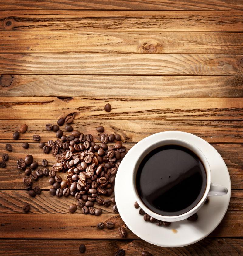 木桌上的浓咖啡和咖啡豆