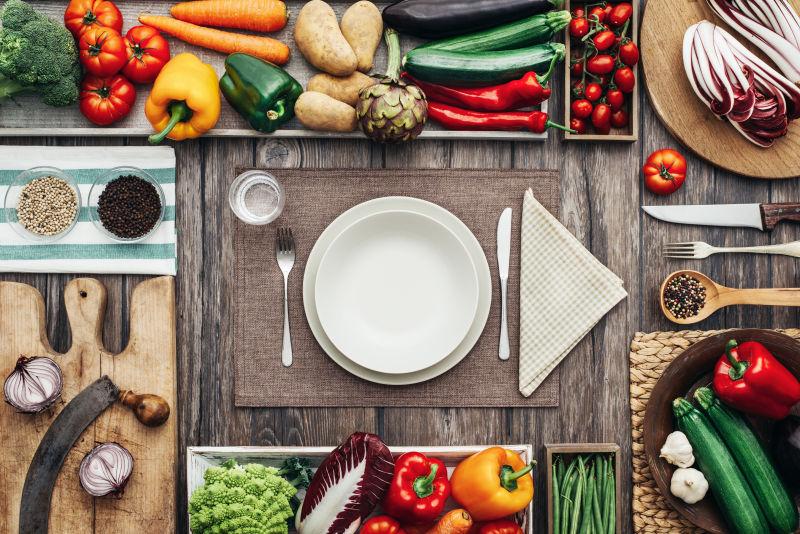 新鲜健康的蔬菜和炊具构成一个老式厨房台面框