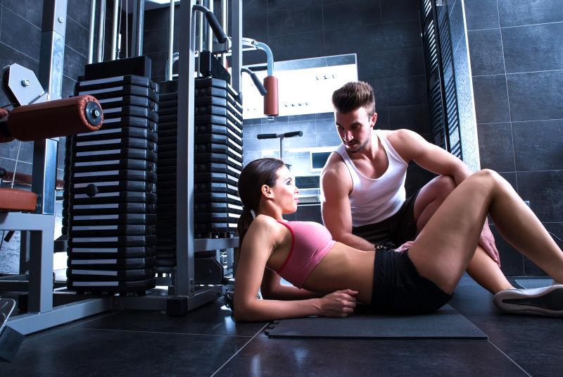 健身房里锻炼期间休息的年轻夫妇