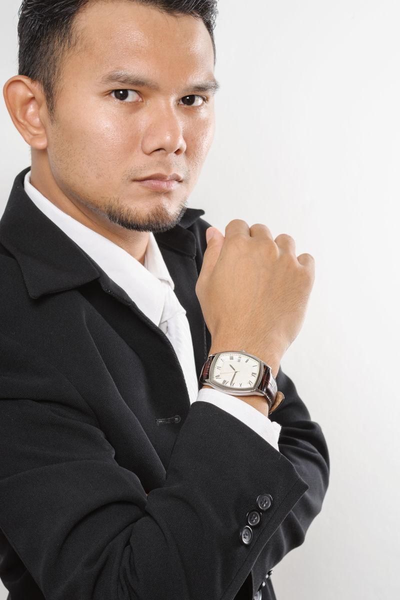 身穿黑色西服戴着手表的男子