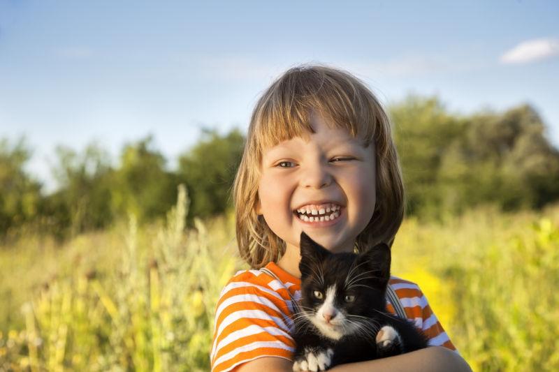 一个快乐的孩子抱着黑色小猫