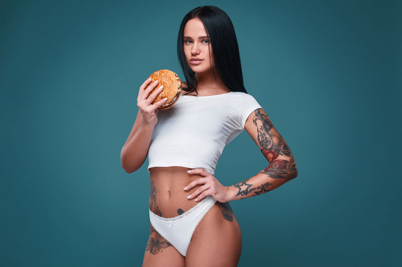 纹身女孩拿着汉堡包