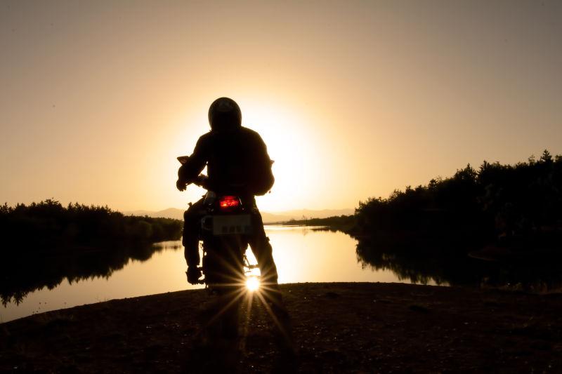 夕阳湖边的摩托车骑手