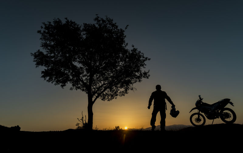 夕阳下的摩托车和人