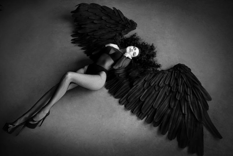 带着黑色翅膀躺在地上的性感美女