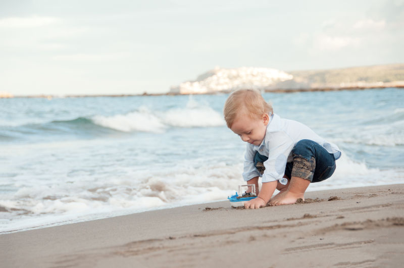 在海滩上玩沙子的小男孩