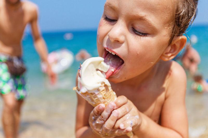 沙滩上吃冰淇淋的小男孩