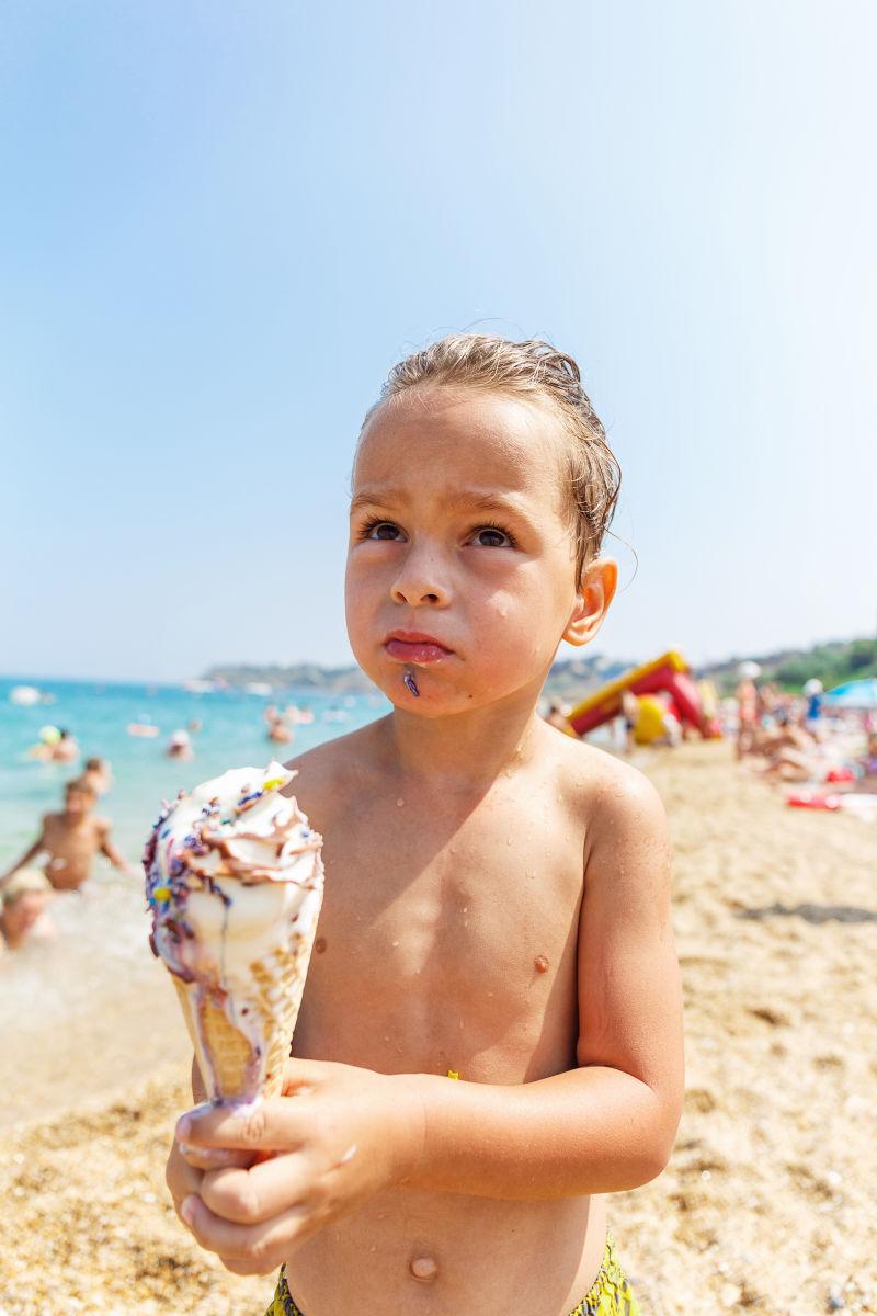 海滩上吃冰淇淋的男孩