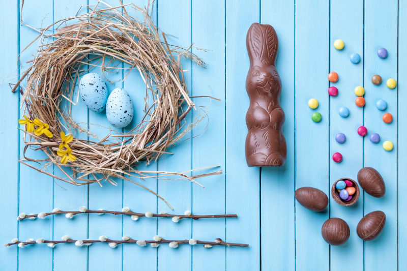 蓝色背景下的复活节彩蛋与巧克力糖果