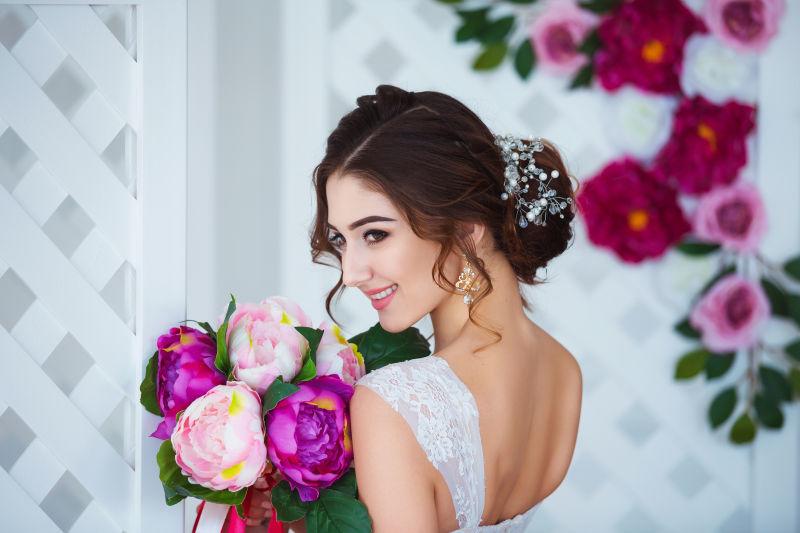 微笑的新娘捧着美丽的花束