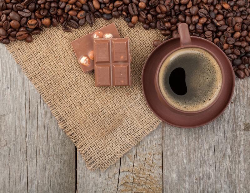 咖啡豆边的巧克力的和咖啡杯