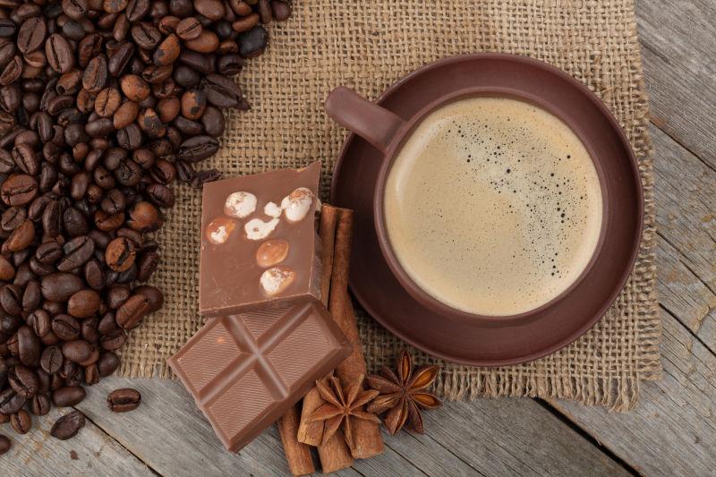 咖啡豆边的咖啡杯和巧克力