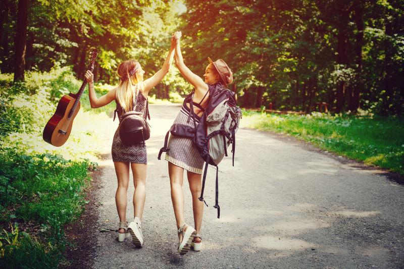 两个女旅行者走过树林穿过马路