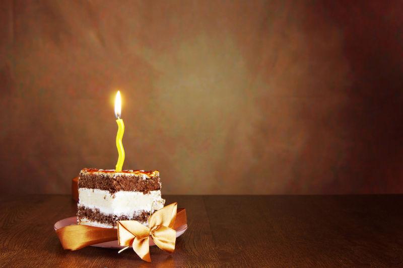 一小块插着蜡烛的生日蛋糕