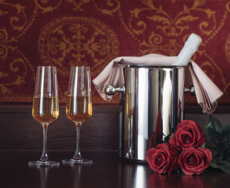 木质板上的香槟酒和玫瑰