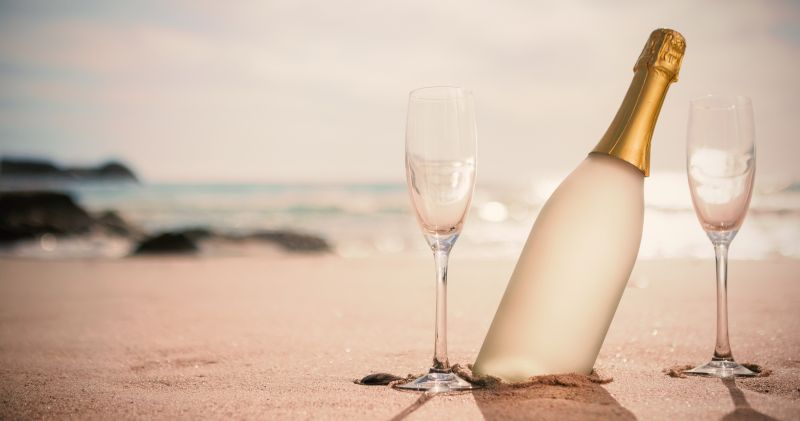 沙滩上的香槟和杯子
