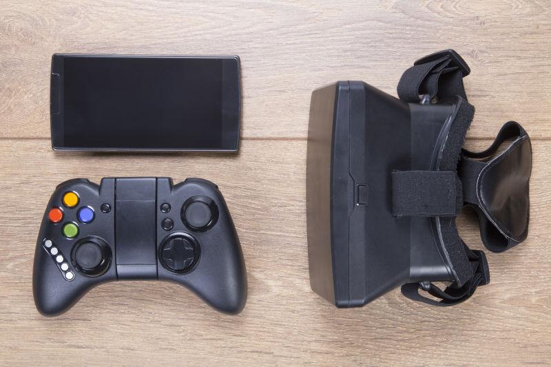 桌子上的VR眼镜游戏控制器和手机