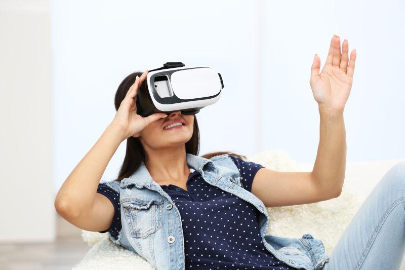 躺在沙发上的女人戴着VR眼镜