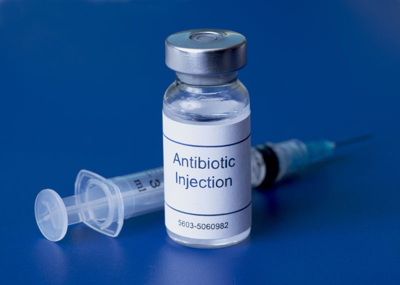 蓝色背景上抗生素注射器瓶与注射器