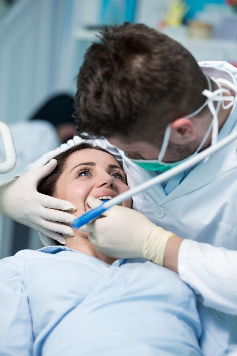 男牙医正在给女病人检查牙齿