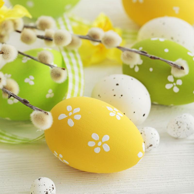 白色桌上黄色和绿色的复活节彩蛋