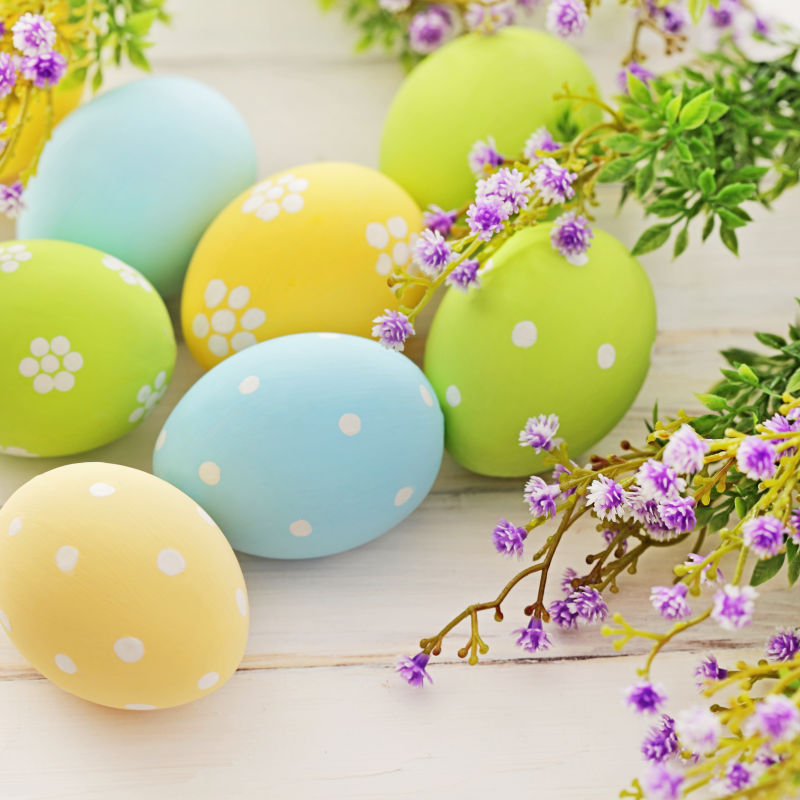 白色桌子上的复活节彩蛋和紫色小花