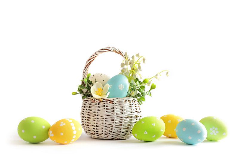 白色背景下白色桌上和篮子里的复活节彩蛋与花朵