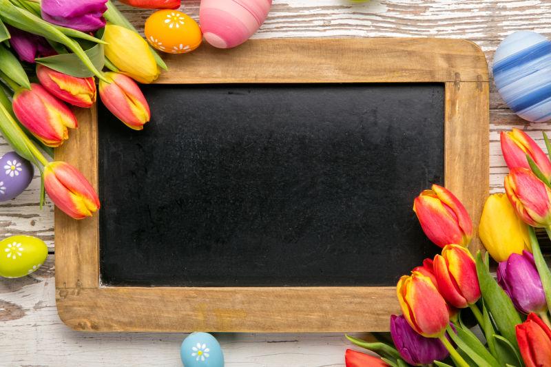 五颜六色的复活节彩蛋和郁金香还有一块黑板