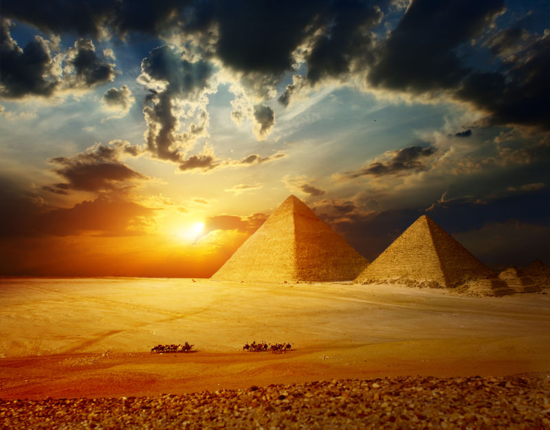 日落下的埃及金字塔和骆驼队