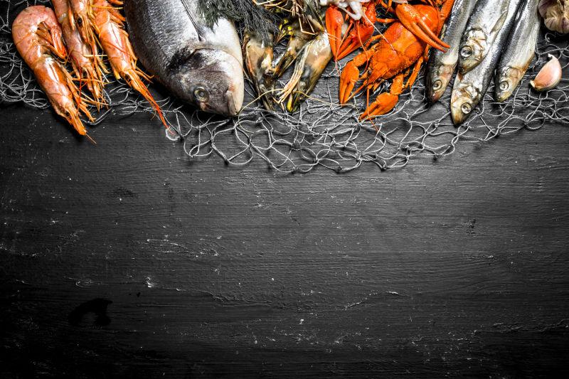 黑色背景渔网上的各种海鲜食材