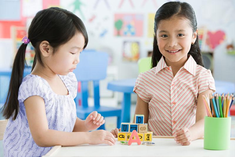 教室内玩积木的两个可爱的小孩子