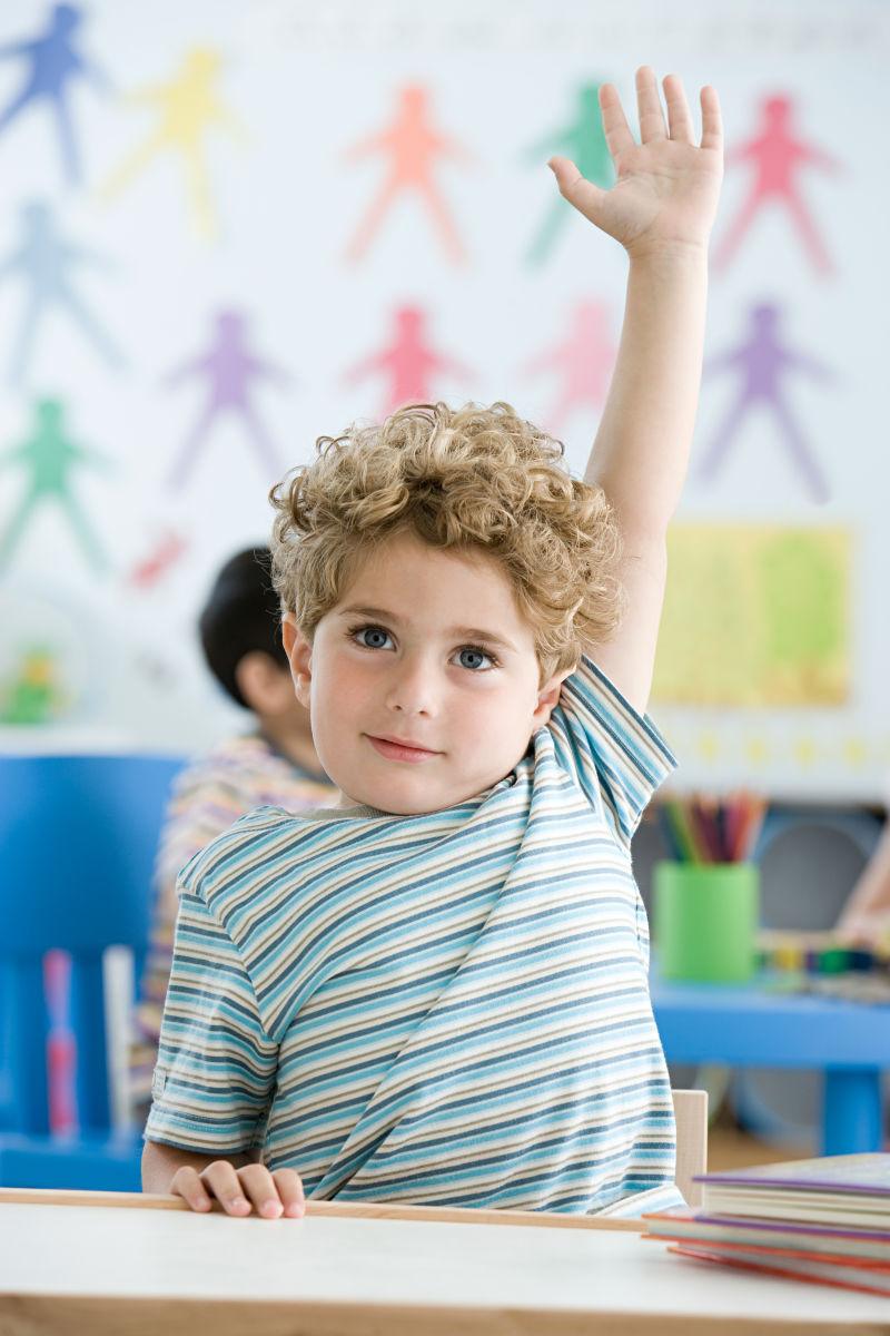 教室内高举手的小男孩