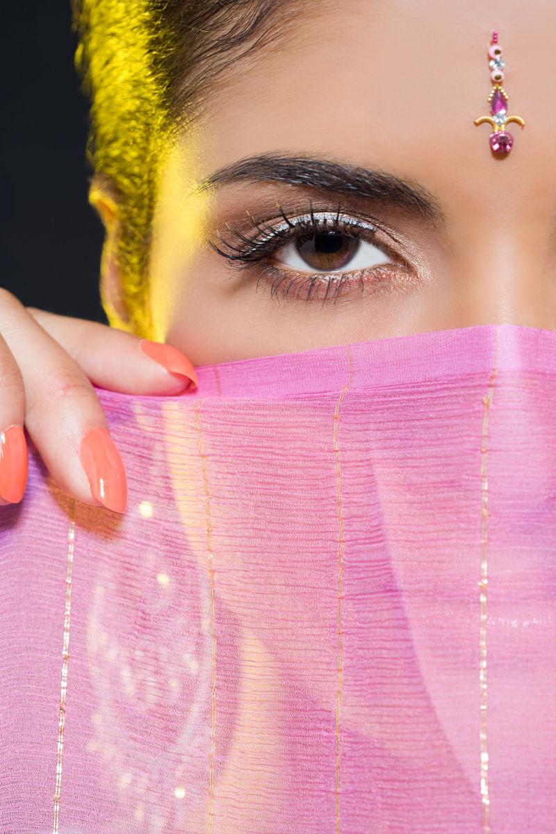 粉红纱巾遮盖着半张脸的印度女人