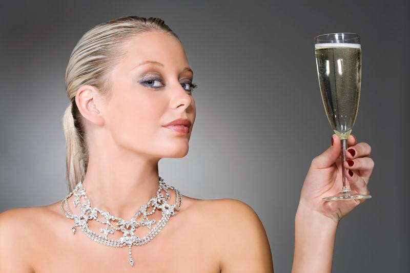 戴钻石项链的美女拿着香槟酒