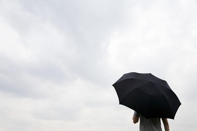 撑着黑色雨伞的男人