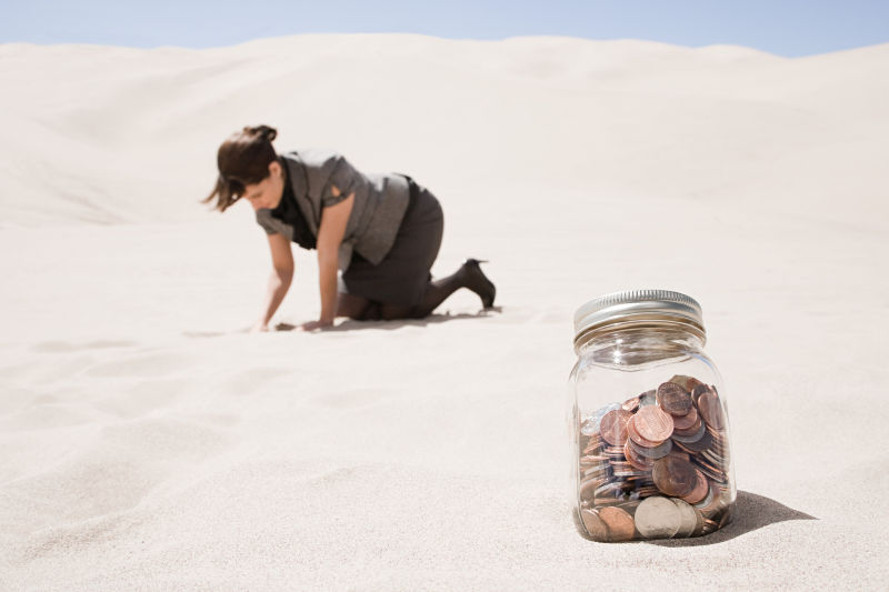 一个储蓄罐跟跪在沙漠上的商人