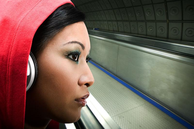 地铁站戴耳机听歌的女人