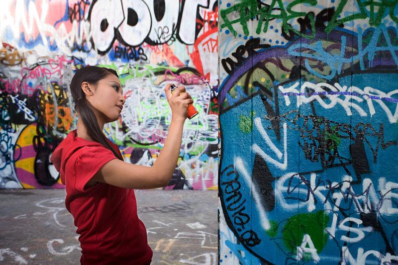 年轻女人在墙壁上涂鸦