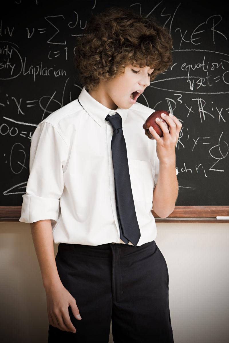 课堂里的学生黑板面前吃苹果