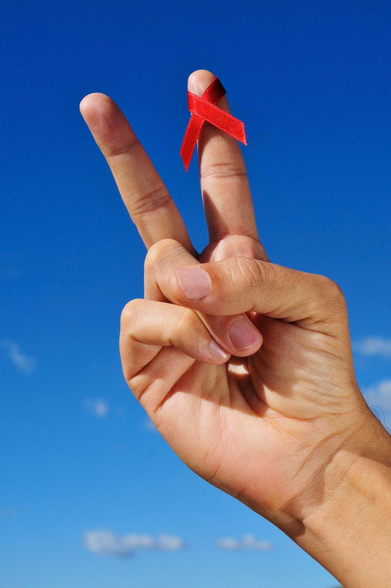 一名男子手持V带红色警示带做艾滋病防治工作