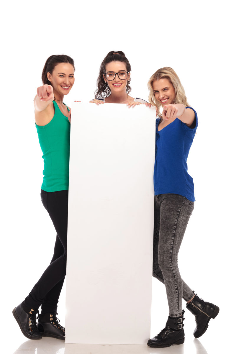 白色背景上扶着空白广告牌的三个美女