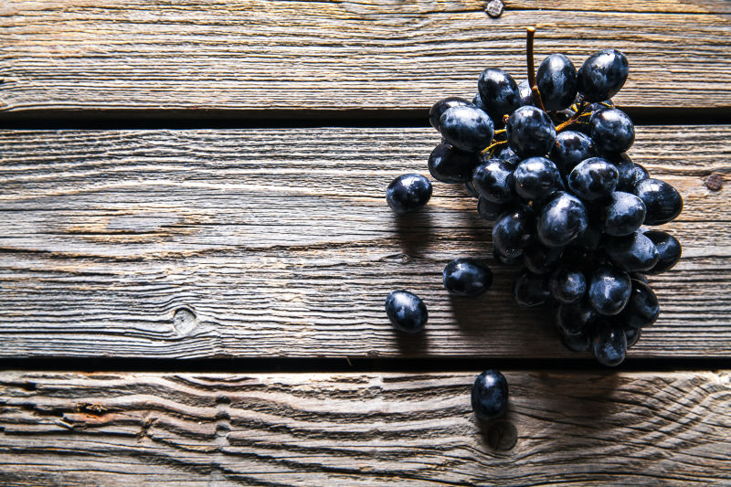 旧木桌上的一串葡萄